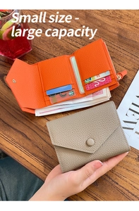 Detail of lychee pattern leather wallet with multi-card slots and snap closure on wood
