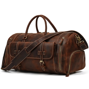 Detail of vintage brown leather travel bag featuring side shoe compartment and bronze hardware