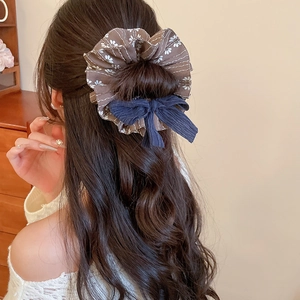 Detailaufnahme von Haargummi mit Blumenmuster und Cord-Schleife für Frisuren