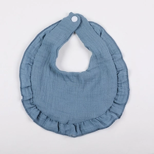 Detailed view of the Morandi blue ruffled muslin baby bib with premium cotton texture
