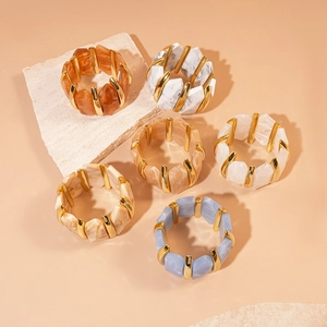Gros plan de bracelets élastiques en acrylique marbré avec des connecteurs dorés