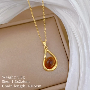 Detail of gold geometric amber pendant necklace with crystal accents on silk