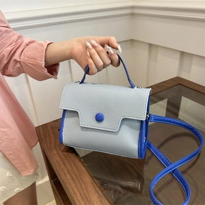 Blue textured leather crossbody bag with top handle and sleek adjustable shoulder strap