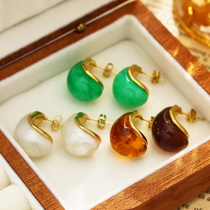 Detailed close-up of retro water-drop earrings in four resin colors in a wooden box