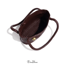 Detailed interior of a woven leather tote bag showing the main compartment and gold hardware