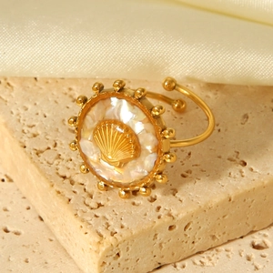 Detailed view of an 18K gold-plated stainless steel scallop ring with mother of pearl inlay