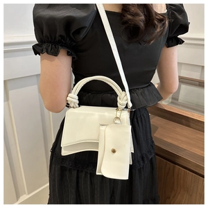 Détail du sac à main blanc en similicuir avec rabat asymétrique et poignée nouée chic