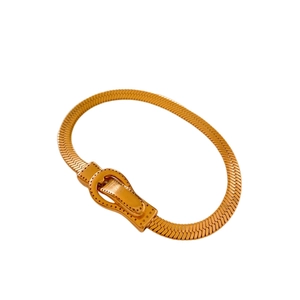 Bracelet chaîne serpent dorée avec fermoir magnétique sur un fond blanc épuré