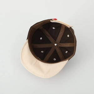 Vue intérieure d'une casquette en coton à six panneaux avec coutures marron et bouton métallique
