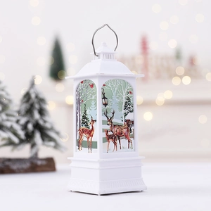 White Christmas lantern with reindeer print and warm LED flame effect on a festive desk
