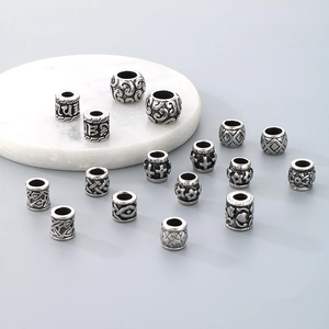 Macro view of vintage silver stainless steel barrel beads with various engraved patterns