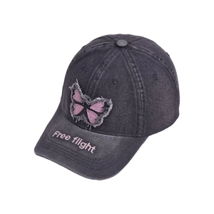 Detailed close-up of butterfly embroidery and pink Free flight text on washed denim hat