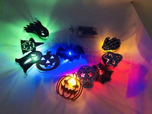 Macro shot of colorful LED Halloween string lights with pumpkin and bat shapes