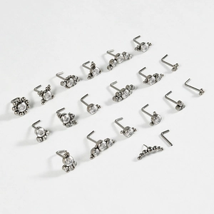 Collection of 20 titanium L-shaped nose studs with sparkling zircon stones on white background