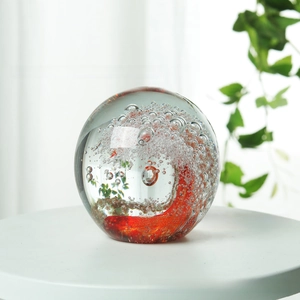 Macro detail of crystal paperweight with red spiral pattern and decorative bubbles