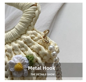 Detail of golden metal hook and pearl handle on handmade white woven shell bag