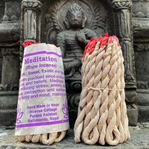 Encens népalais artisanal fait main pour méditation placé près d'une statue de Bouddha