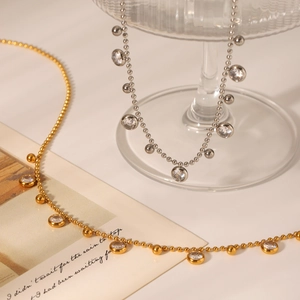Detail of beaded tassel necklaces in gold and silver with sparkling zircon pendants