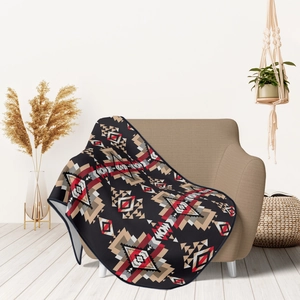 Detailed texture of flannel blanket with red and black geometric ethnic patterns on sofa