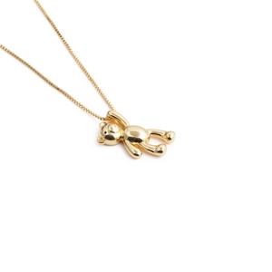 Macro detail of golden bear pendant with sparkling zircon inlay and polished metallic finish