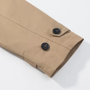 Detailed close-up of khaki trench coat cuffs with dual resin buttons and fine stitching