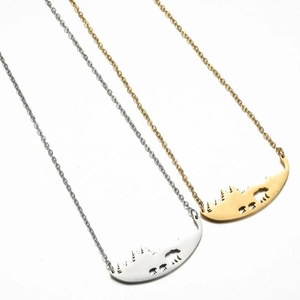 Minimalist gold and silver necklaces featuring hollow forest and bear silhouette pendants