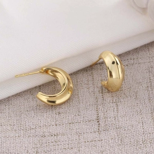 Minimalist S925 sterling silver hoop earrings with a textured gold finish on soft fabric