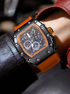 Detalle de reloj automático de hombre tipo tonel con correa de caucho naranja y esfera esqueleto
