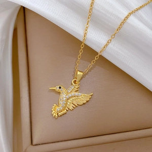Detail of a gold-plated hummingbird pendant necklace encrusted with white zircon stones
