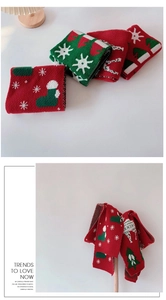 Close-up of Christmas knit scarf featuring festive reindeer and snowflake patterns
