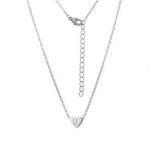 Détail macro du pendentif cœur en acier inoxydable avec lettre U gravée sur une chaîne argent