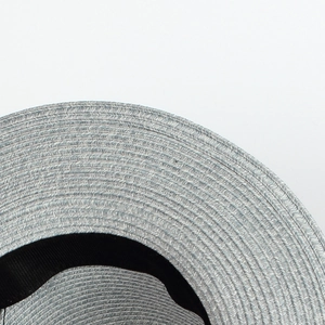 Close-up of the fine woven texture and inner sweatband of a grey straw beach sun hat