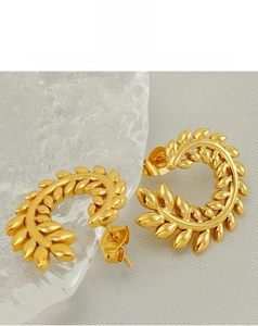 Detailed macro of vintage gold-plated wheat-ear C-shape stud earrings for women