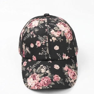 Detail of floral baseball cap featuring pink flower print on black canvas fabric