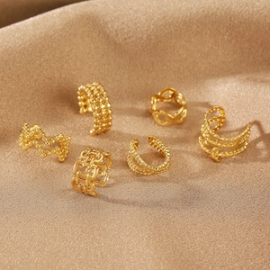 Detailed view of 6-piece gold geometric ear cuff set on elegant champagne silk fabric