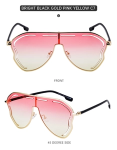 Close-up of oversized shield sunglasses with pink-yellow gradient lenses and gold frame