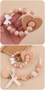 Detail of pink silicone beads and wooden heart teether rattle in a handmade baby set