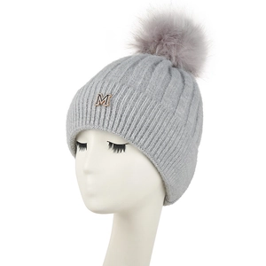 Bonnet en maille côtelée grise avec pompon en fausse fourrure et insigne métallique M doré