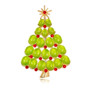 Detailed view of a golden Christmas tree brooch with green gems and red rhinestones