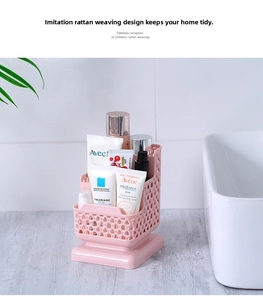 Pink rattan-style desk organizer with multiple compartments for skincare on a white vanity