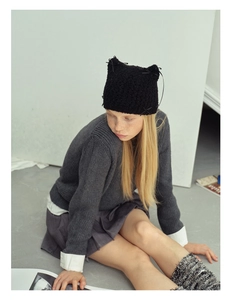Close-up of black knit cat ear hat with cute bow details and textured crochet pattern