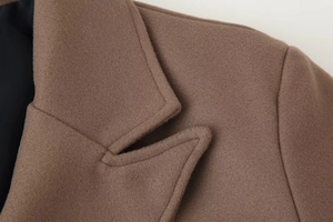Close-up of brown wool coat lapel featuring premium stitching and soft texture
