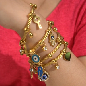 Macro shot of gold-plated braided cable bracelets with blue evil eye and hamsa charms