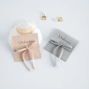 Close-up of pink and grey microfiber jewelry pouches with elegant ribbon ties