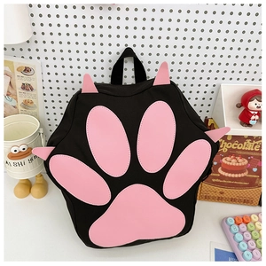 Close-up of cute black cat paw backpack with pink 3D paw pads on a white pegboard background