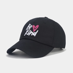 Vue latérale d'une casquette noire en coton avec broderie Be Kind et cœur rose