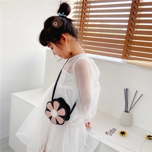 Detail view of cute 3D flower-shaped crossbody bag on a child wearing a white dress