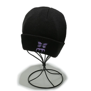 Détail de la broderie papillon violet et lettrage Dreams sur bonnet noir en tricot