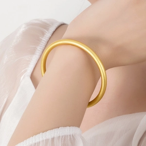 Classic frosted gold bangle with a minimalist design worn on a female wrist