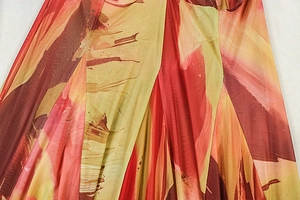 Detailed macro shot of abstract red and orange print on smooth lightweight fabric